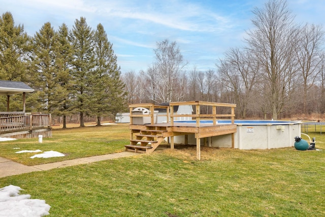 view of yard featuring an outdoor pool and a deck