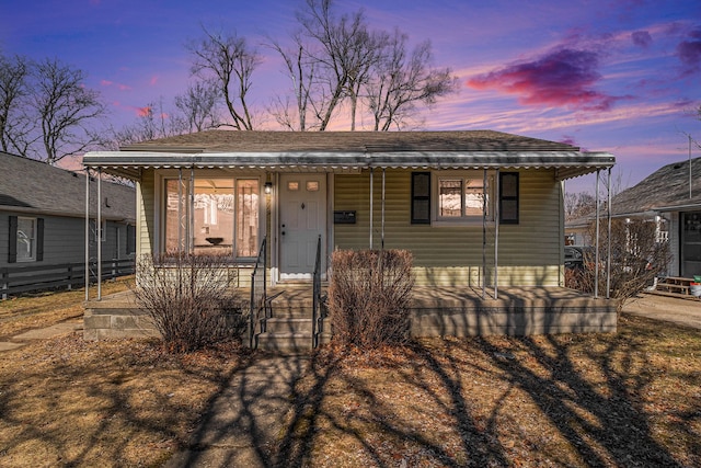 bungalow-style house featuring covered porch and a shingled roof