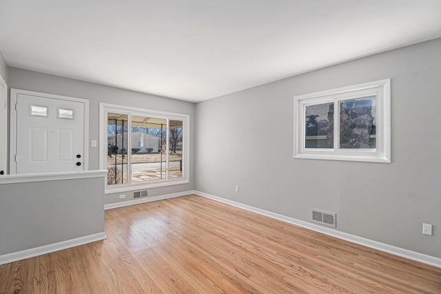 empty room with visible vents, baseboards, and light wood-style floors