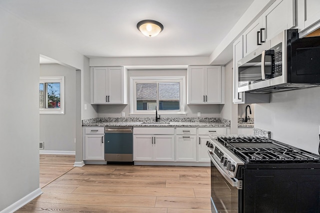 kitchen featuring plenty of natural light, light wood-style flooring, appliances with stainless steel finishes, and a sink