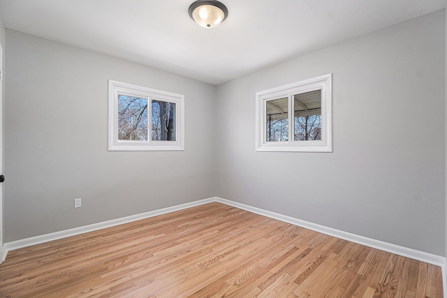 spare room featuring light wood-style flooring and baseboards