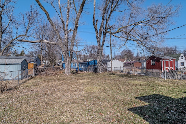 view of yard featuring a storage shed, an outbuilding, a residential view, and a fenced backyard