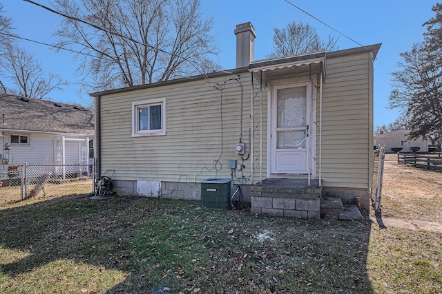 back of house featuring central AC unit, fence, a chimney, entry steps, and crawl space