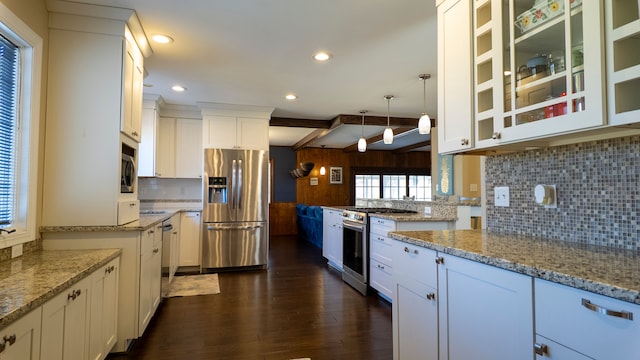 kitchen with dark wood finished floors, light stone countertops, backsplash, and stainless steel appliances