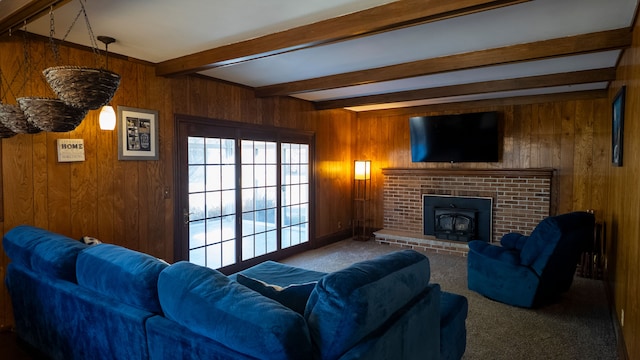 living room featuring beam ceiling, carpet floors, wood walls, and a fireplace