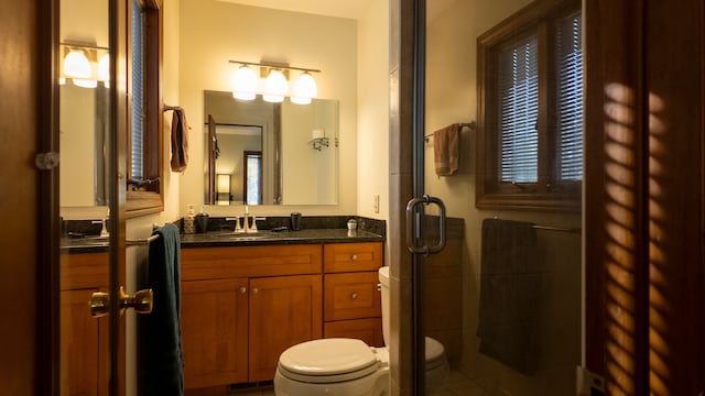 full bathroom featuring visible vents, a shower stall, toilet, and vanity