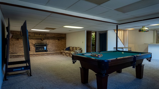 recreation room featuring billiards, a brick fireplace, a drop ceiling, and carpet floors