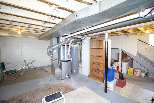 unfinished basement featuring water heater, stairs, and heating unit