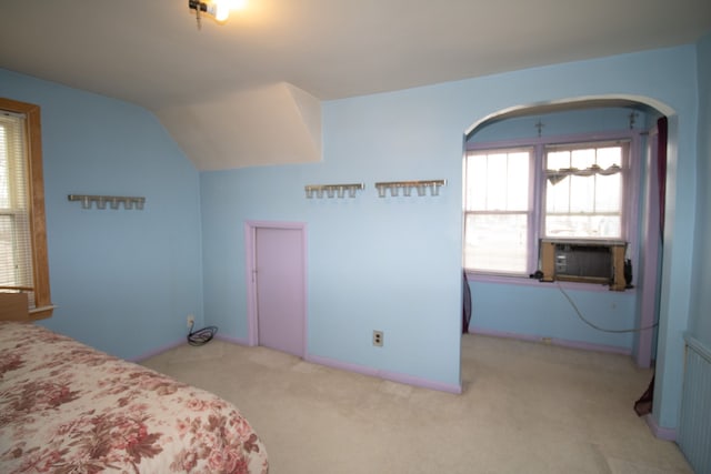 carpeted bedroom with lofted ceiling, arched walkways, and cooling unit