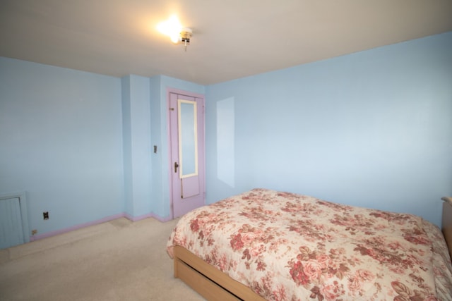 bedroom featuring radiator and light colored carpet