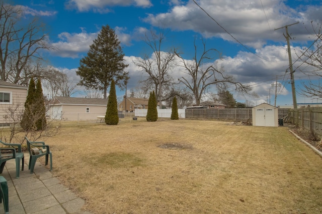 view of yard featuring an outbuilding, a shed, and a fenced backyard