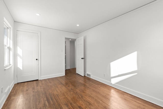 unfurnished bedroom with visible vents, baseboards, wood finished floors, and recessed lighting