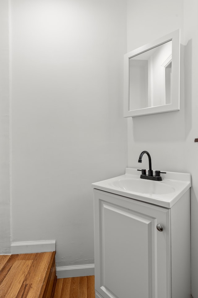 bathroom featuring wood finished floors, vanity, and baseboards