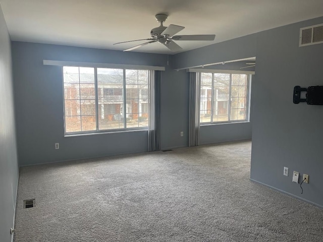 spare room with ceiling fan, visible vents, and a healthy amount of sunlight