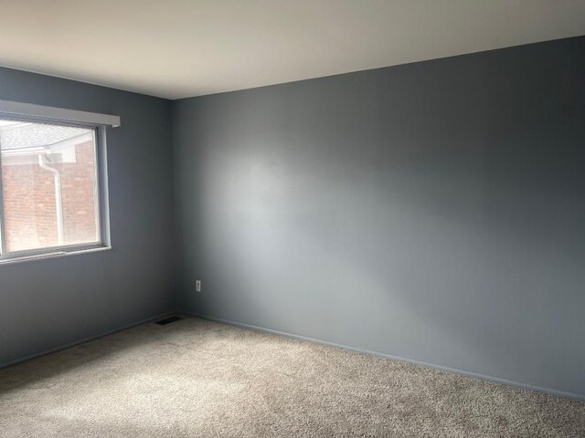 carpeted spare room featuring visible vents