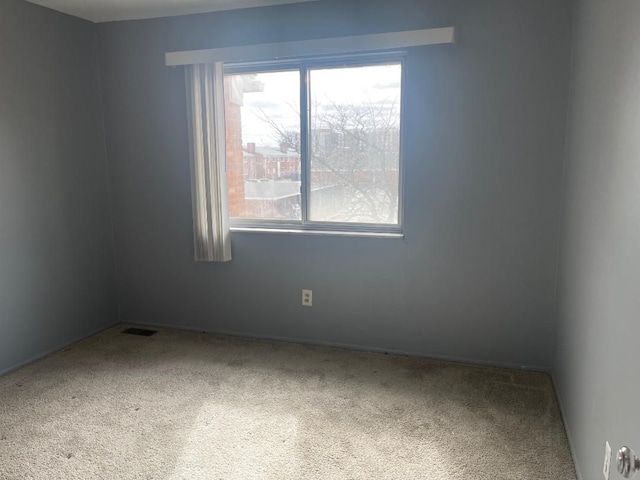 unfurnished room featuring carpet floors and visible vents