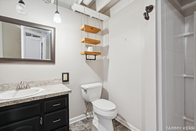 bathroom featuring toilet, baseboards, and vanity