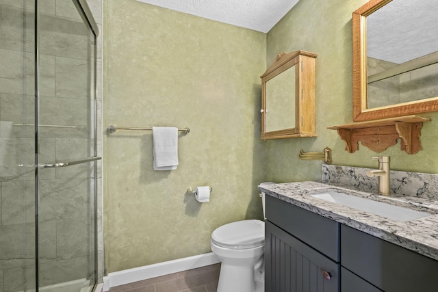 full bathroom with vanity, a shower stall, toilet, and baseboards