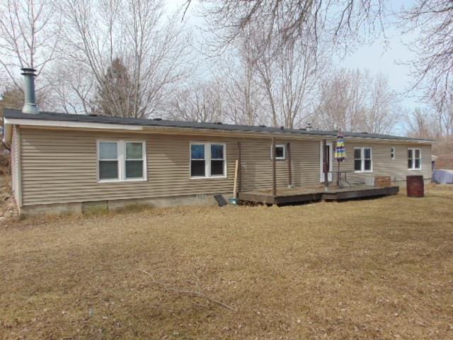 rear view of house featuring a deck, crawl space, and a lawn