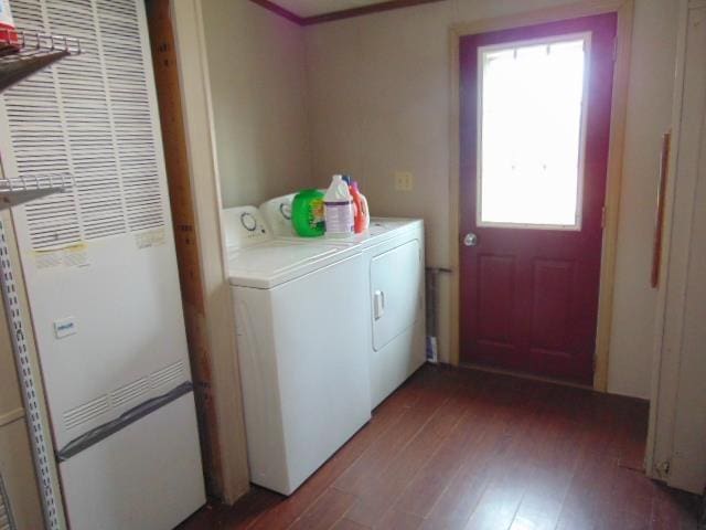 laundry area with a heating unit, washer and clothes dryer, and wood finished floors