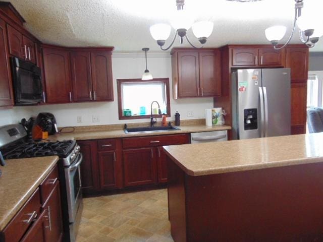 kitchen with light countertops, an inviting chandelier, appliances with stainless steel finishes, a sink, and a textured ceiling