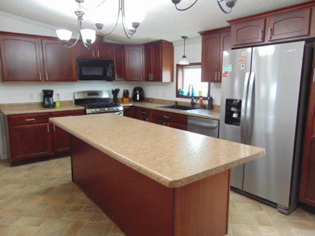 kitchen with appliances with stainless steel finishes, a center island, light countertops, and a sink