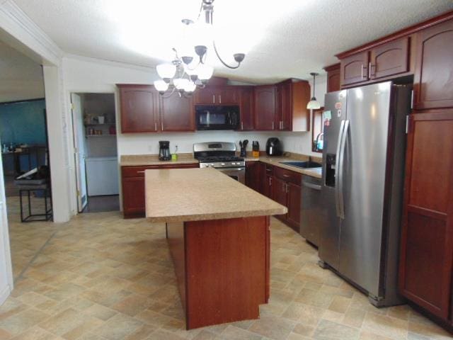 kitchen with a notable chandelier, stainless steel appliances, a kitchen island, a sink, and light countertops