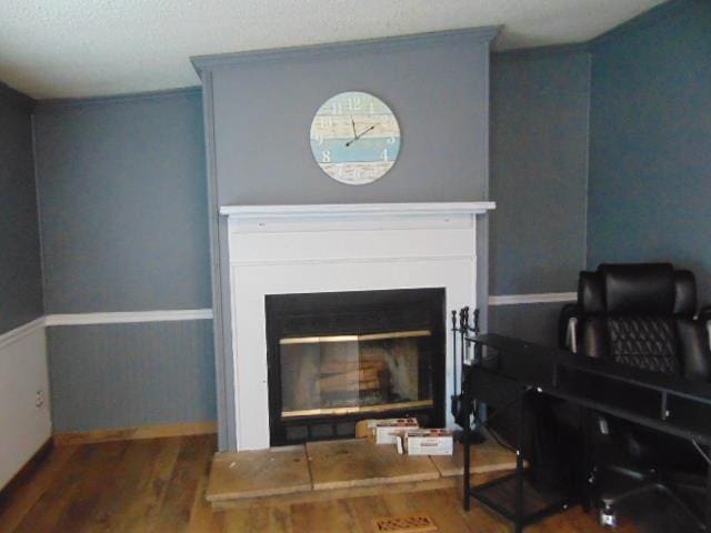 room details featuring wood finished floors and a glass covered fireplace