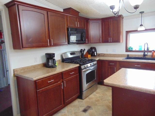 kitchen with visible vents, stainless steel range with gas stovetop, light countertops, black microwave, and a sink