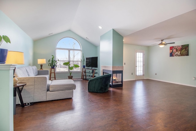 living room with vaulted ceiling, wood finished floors, a multi sided fireplace, and baseboards