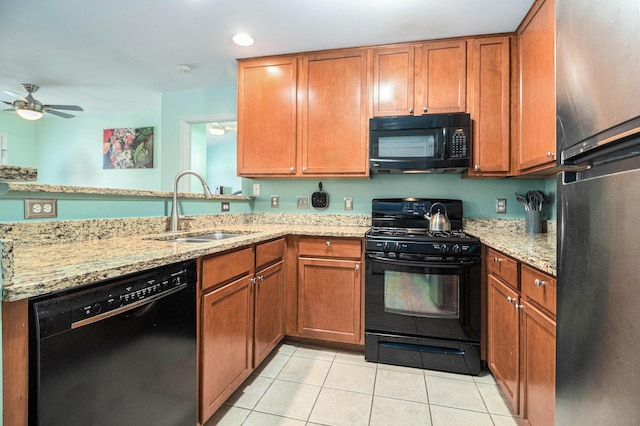 kitchen with light tile patterned floors, black appliances, a sink, and brown cabinets