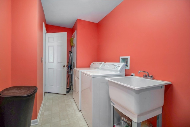 washroom featuring laundry area, a sink, baseboards, independent washer and dryer, and light floors