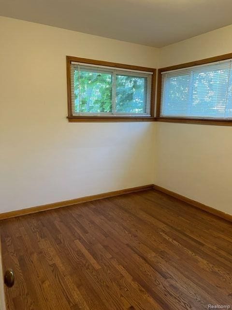 unfurnished room with wood finished floors and baseboards