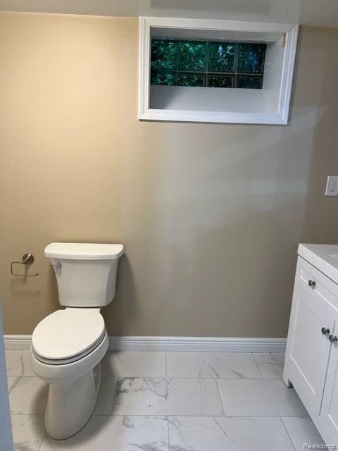 bathroom with marble finish floor, baseboards, and vanity