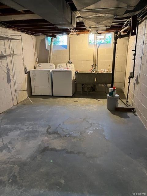 basement featuring a sink and washing machine and clothes dryer