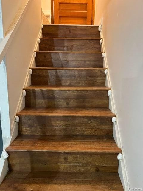 stairs featuring wood finished floors