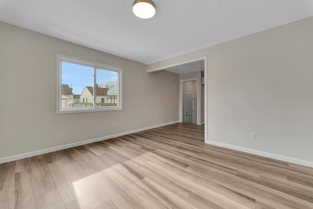 empty room with light wood-type flooring and baseboards