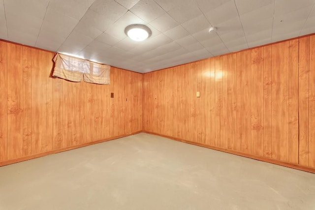 finished basement featuring wood walls, elevator, and baseboards