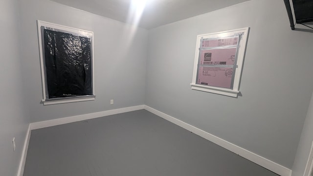 spare room with concrete floors and baseboards