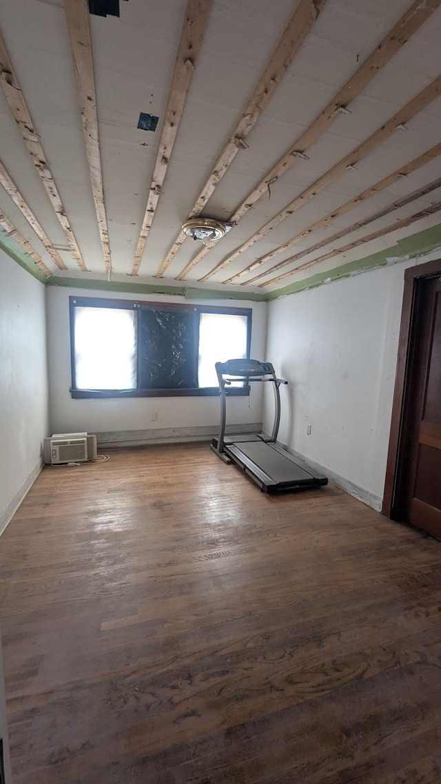 exercise area with a healthy amount of sunlight, baseboards, and wood finished floors