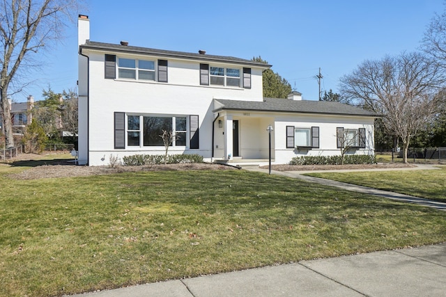 traditional-style home with a front yard, fence, and a chimney