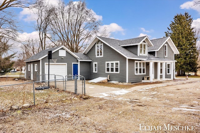 view of front of property with a garage, driveway, a shingled roof, and fence