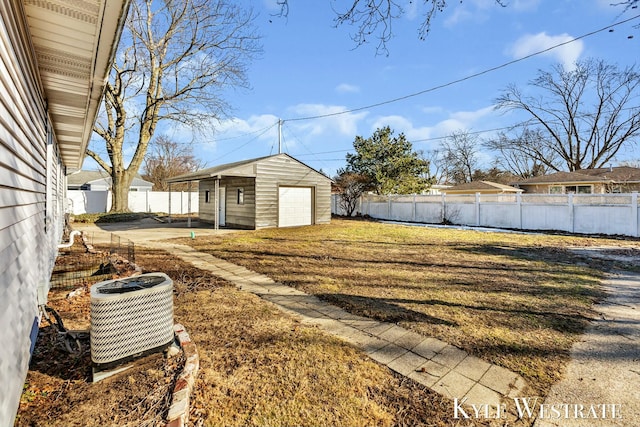 view of yard featuring a fenced backyard, a detached garage, central AC, and an outdoor structure