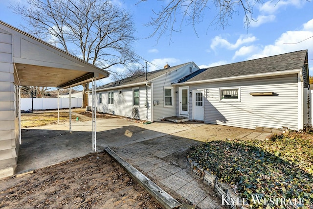 rear view of property featuring roof with shingles, a patio area, and fence