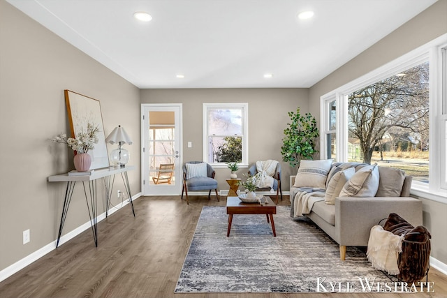 living area with baseboards, wood finished floors, and recessed lighting