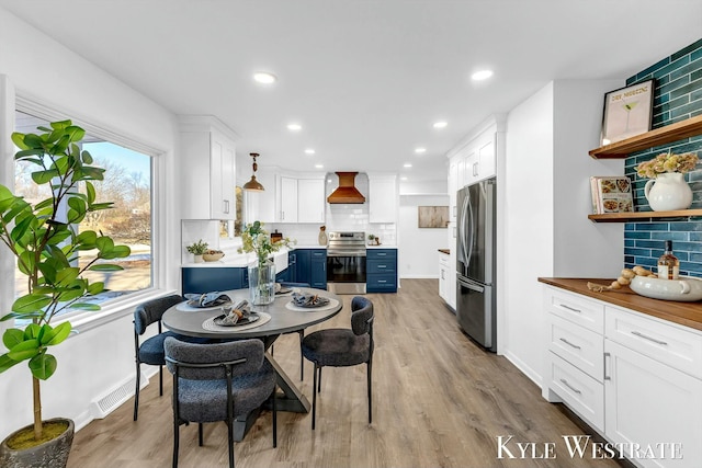 dining area with light wood-style floors, visible vents, baseboards, and recessed lighting