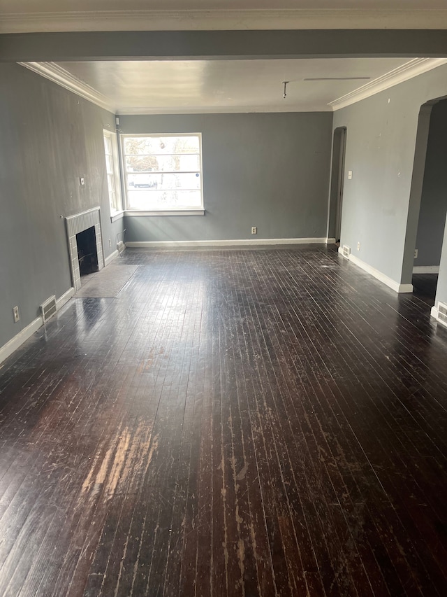 unfurnished living room with arched walkways, a fireplace, baseboards, wood-type flooring, and crown molding