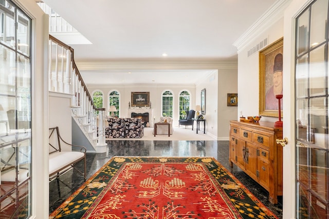 foyer with visible vents, granite finish floor, stairway, a warm lit fireplace, and baseboards