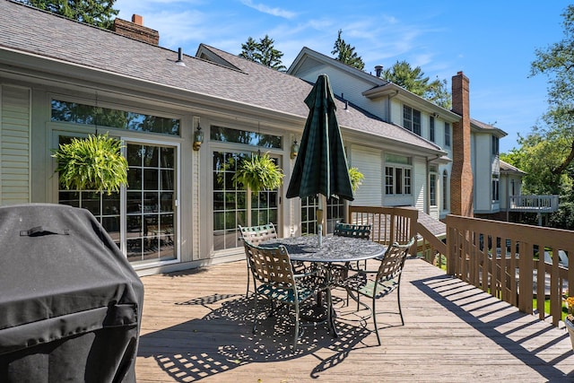 wooden deck with a grill and outdoor dining space