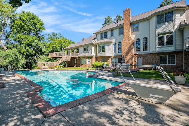 pool featuring a patio area, stairway, and a wooden deck